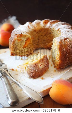 Homemade Apricot Bundt Cake And Fresh Apricots On Wooden Background