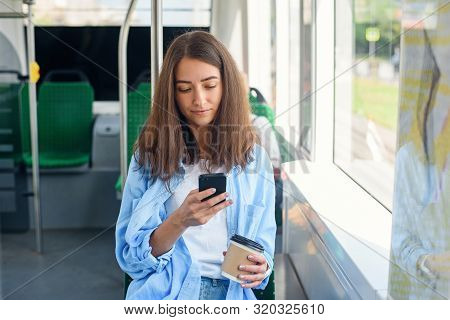 Pretty Female Passenger Sits With Smartp Hone While Moving In The Modern Tram Or Subway. Trip At The