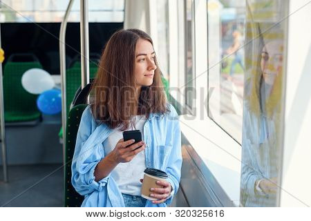 Pretty Female Passenger Sits With Smartp Hone While Moving In The Modern Tram Or Subway. Trip At The