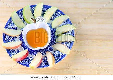 Jewish Holiday Rosh Hashana Background With Honey And Slices Of Apple On Wooden Table. During The Je