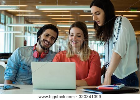 University Students Using Laptop In University Library.