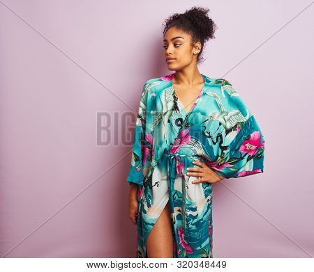 Young beautiful african american woman standing wearing elegant colorful caftan