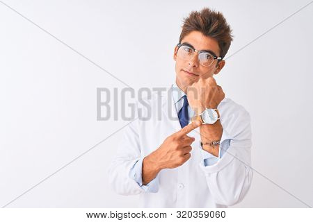 Young handsome sciencist man wearing glasses and coat over isolated white background In hurry pointing to watch time, impatience, looking at the camera with relaxed expression