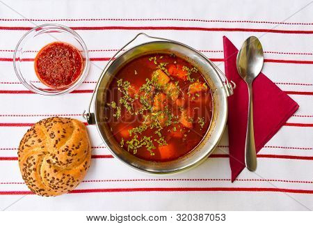 Hungarian Home Made Goulash Soup From Above In A Small Metal Goulash-kettle Served. Chili Pepper Cre