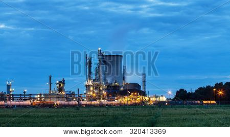 View On Illuminated Operational Chemical Plant In Twilight