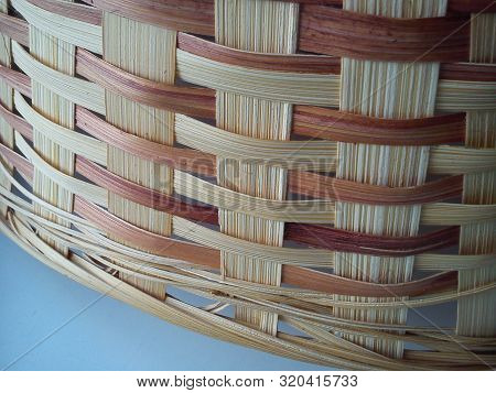 Close-up Of A Part Of A Bast Basket In Warm Beige, Brown, Burgundy Colors On A Blue Background