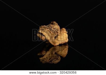 One Piece Of Roseship Of Lingonberry Strawberry Fruit Tea Macro Isolated On Black Glass