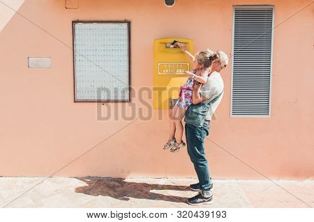Vatican/vatican - June, 21, 2019: Father And His Little Daughter Drops A Postcard In A Mailbox In Th