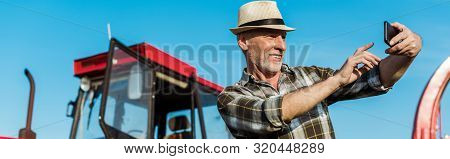 Panoramic Shot Of Happy Self-employed Farmer Taking Selfie Near Tractor