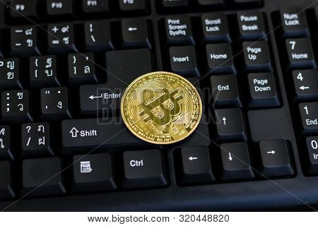 Bitcoin With Black Keyboard On Old Wood