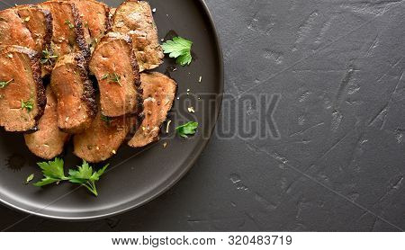 Grilled Sliced Beef Liver On Plate Over Black Stone Background With Free Text Space. Cooked Liver(of