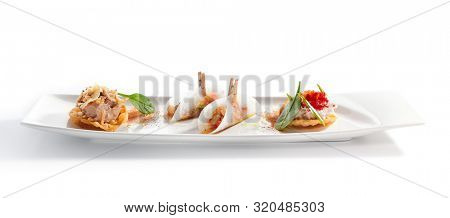 Taco with seafood assorti close up. Mexican traditional dish. Wheat tortilla with sea food fillings on plate. Served delicious snacks. Appetizer composition isolated on white background