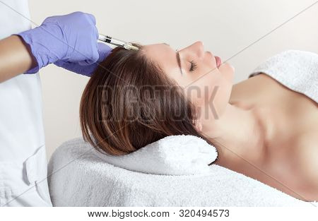 There Is A Woman And A Cosmetologist, The Woman Is Lying And The Doctor Is Making The Procedure Of M