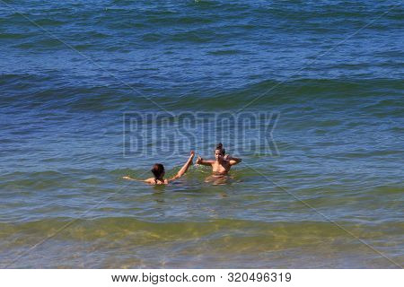 Zelenogradsk, Kaliningrad Region, Russia - June 18, 2019: Unknown Young Women Bathing In Blue Water 