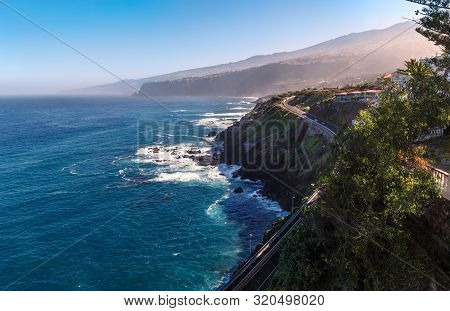 Coastline Of The Atlantic Ocean With Mountains And Road View In Puerto De La Cruz, One Of The Popula