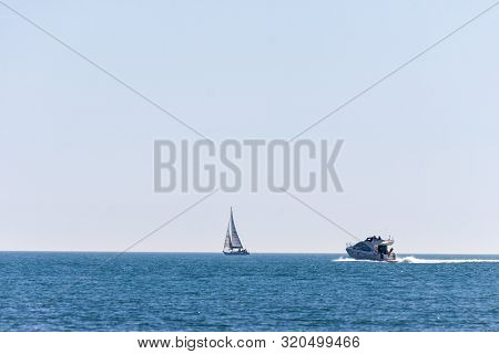 A Motor Boat And A Sail Boat On The Sea - Photography