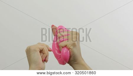 Woman Hands Playing With Oddly Satisfying Pink Slime On White Background. Sticky Gooey Substance. Re
