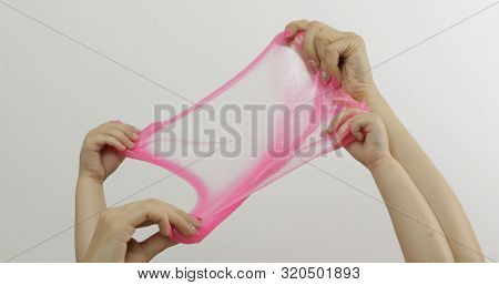 Woman And Child Hands Playing With Oddly Satisfying Pink Slime On White Background. Sticky Gooey Sub