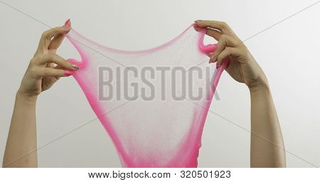 Woman Hands Playing With Oddly Satisfying Pink Slime On White Background. Sticky Gooey Substance. Re