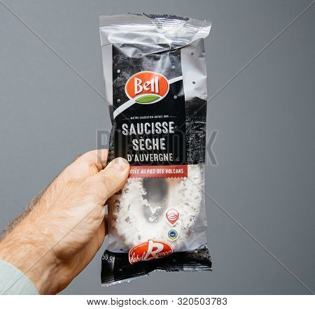 Paris, France - Aug 21, 2019: Man Hand Holding Delicious French Sausage Saucisse Seche Dauvergne Tra