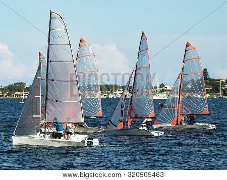 Children Sailing In Small 29er Dinghies For Fun And In Competition. Teamwork By Junior Sailors Racin