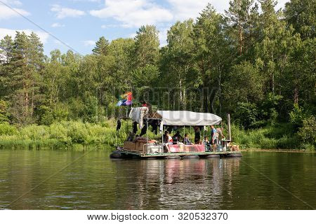 People Relax On Primitive Raft During A Canoe Rafting On The Belaya River. Tourists Rafting Down Or 