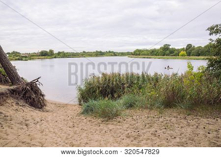 City Carnikava, Latvian Republic. Fisherman Catching Fish In The River, Nature, Silence And Water Wa