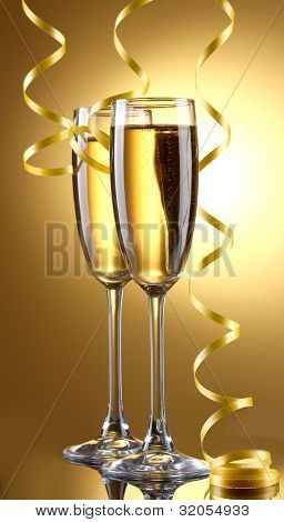 glas champagne og streamer på gul baggrund