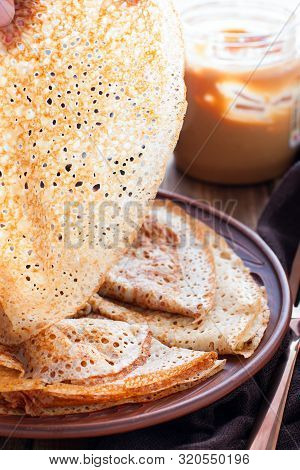Openwork Pancakes In A Female Hand On The Lumen, Selective Focus