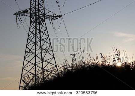 Power Plant, Electricity Transmission Lines. Silhouettes Of High Voltage Towers With Electrical Wire
