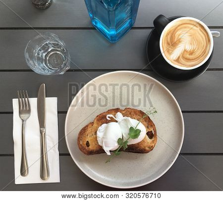 Breakfast - Poached Eggs On Toast With Coffee On A Table In An Outdoor Cafe.