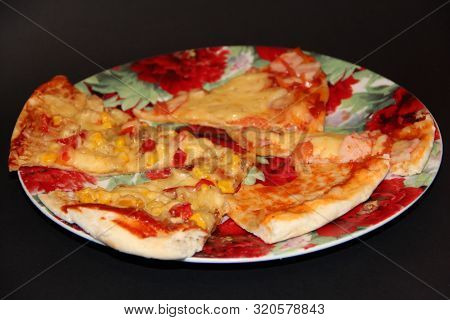 Slices Of Fresh Appetizing Pizza With Delicious Ingredients On Colorful Plate On Black Background. T