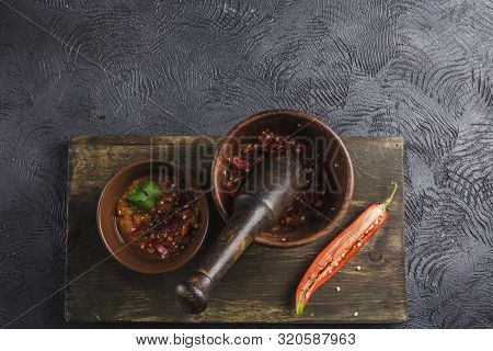 Spicy Chili On A Dark Background In Ceramic Plates On A Wooden Board, Flatlay. Used As An Ingredient