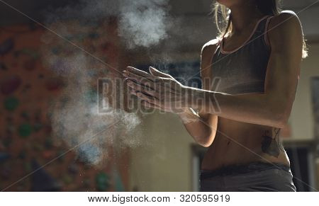 Woman Climber Is Chalking Hands With White Chalk Powder Before Climb In Indoor Climbing Gym. Woman G