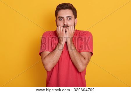 Studio Shot Of Young Man Wearing Red T Shirt Standing Isolated Over Yellow Background, Guy Looking S