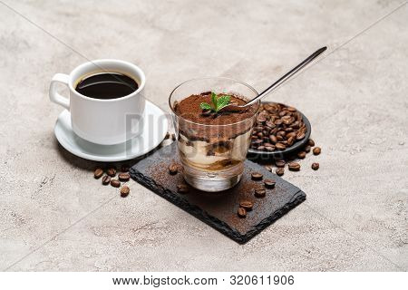 Portion Of Classic Tiramisu Dessert In A Glass Cup On Stone Serving Board And Fres Espresso Coffee O