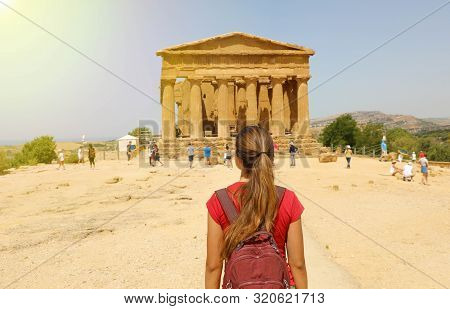 Young Woman Looks At Concordia Temple In The Valley Of The Temples Of Agrigento, Sicily. Traveler Gi