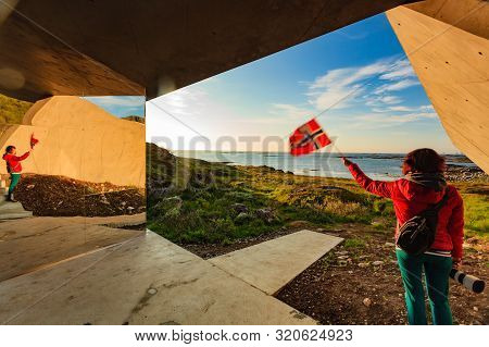 Tourist Woman With Norwegian Flag Enjoying Sea Coast View From Bukkekjerka Rest Stop Area On Andoya 