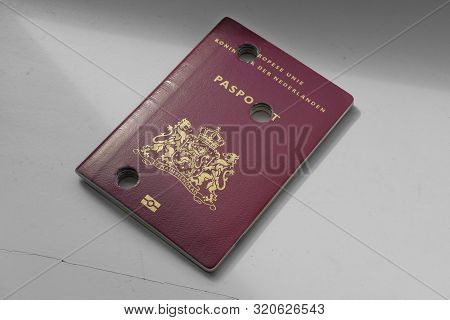 A Dutch Passport Made Unusable With Perforations On A Plain Background