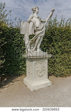 Classic White Marble Statue Of Woman With Cresset In Green Garden Park. Ancient Roman Or Greek Woman
