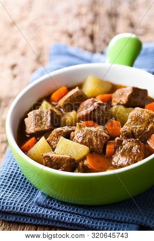 Fresh Homemade Beef Stew With Carrot And Potatoes Served In Green Bowl (selective Focus, Focus One T