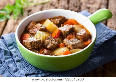 Fresh Homemade Beef Stew With Carrot And Potatoes Served In Green Bowl (selective Focus, Focus One T