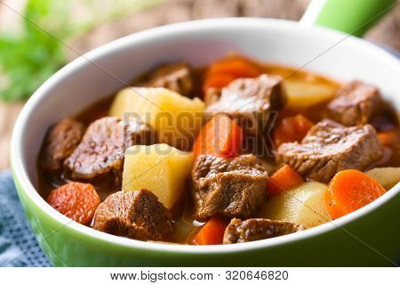 Fresh Homemade Beef Stew With Carrot And Potatoes Served In Green Bowl (selective Focus, Focus One T