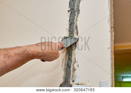 Man Repairing A Wall