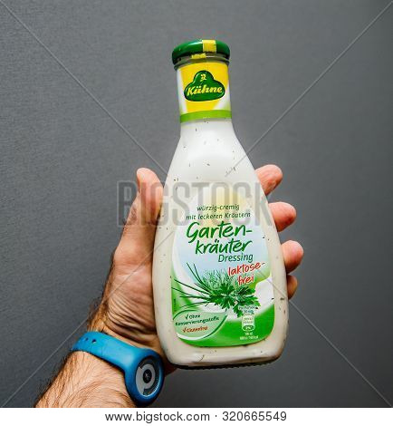 Paris, France - Apr 20, 2019: Man Hand Holding Isolated On Gray Background Bottle With Salad Dressin