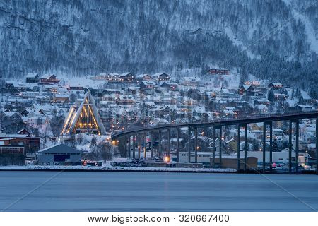 Arctic Cathedral With Famous Tromso Bridge Across Tromsoysundet Strait In The Background, Northern N