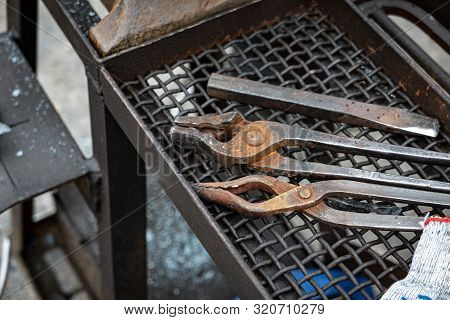 Metal Blacksmith Equipment On A Black Trellis.