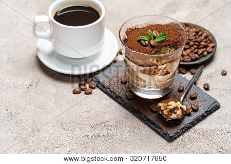 Portion Of Classic Tiramisu Dessert In A Glass Cup On Stone Serving Board And Fres Espresso Coffee O