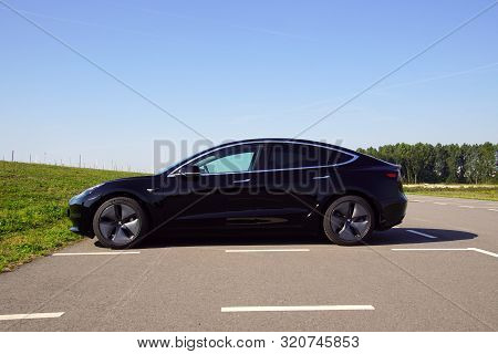 Almere, The Netherlands - August 24, 2019: Black Tesla Model 3 Parked On A Public Parking Lot. Nobod