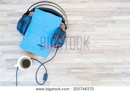 Audio Book Concept. Black Headphones With Books And Cup Of Fresh Coffee On Wooden Table. Top View